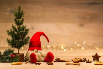 red christmas wretch next to fir tree and cinnamon sticks
